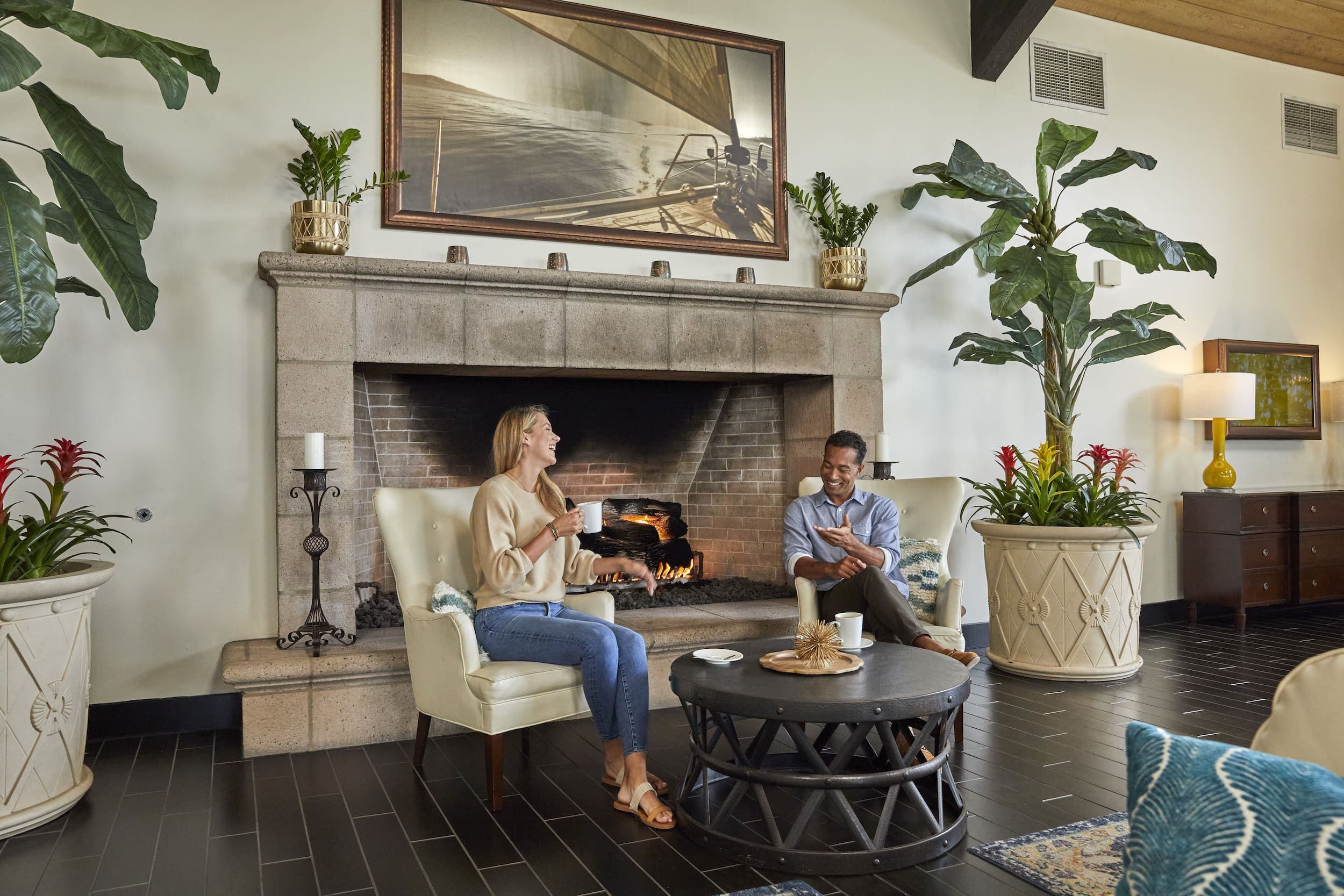 Two people sitting in front of the Kona Kai's lobby fireplace having coffee